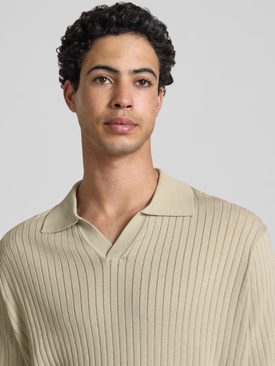 Männermodel trägt Relaxed Fit Poloshirt aus Viskose-Mix Modell 'FLINT' von Only & Sons in Beige mit Strukturmuster, Nahaufnahme Oberkörper.