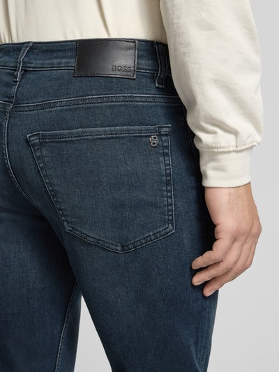 Mężczyznamodel nosi Straight Fit Jeans aus Baumwoll-Mix Modell 'RE.MAINE BO S.AVE' od BOSS Orange, denim, prosty krój, pięć kieszeni, detalowe nity, bawełniany materiał z domieszką, widoczna naszywka z logo, detalowa naszywka, zapięcie na guzik i ukryty zamek, z szlufkami na pasek, perspektywa: detalowa tylna część bioder