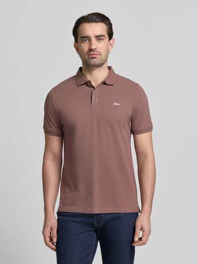 Męski model nosi Regular Fit Poloshirt aus reiner Baumwolle von s.Oliver RED LABEL, jednolity kolor, krój regular fit, krótki rękaw, piqué, bawełna, detal z logo, widok całej sylwetki z przodu.
