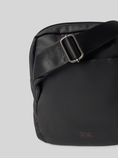 Produktfoto, Crossbody Bag mit Statement-Print Modell 'EXPLORE' von camel active, schwarze Tasche mit Rundum-Reißverschluss und verstellbarem Schulterriemen, Detailaufnahme, Herren Crossbody Bag