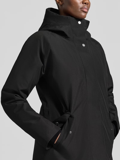 Vrouwenmodel draagt zwarte dames parka van Didriksons, regular fit met capuchon, steekzakken, Model 'Alana', Nahaufnahme Oberkörper, Ruglengte maat 36: 90 cm, Schouderbreedte: 38 cm, Borstwijdte: 48 cm, Mouwlengte: 74 cm.