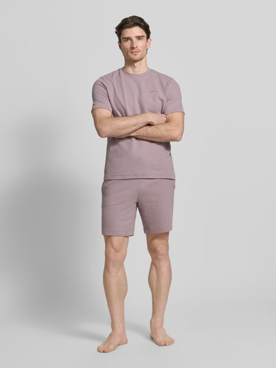Męski model nosi Regular Fit Sweatshorts aus Baumwoll-Mix Modell 'AUSTIN' od HUGO, kolor jednolity, krótki krój regular fit, materiał w fakturze wafla, elastyczny ściągacz, boczne kieszenie, bawełniany mix, widok całej sylwetki z przodu.