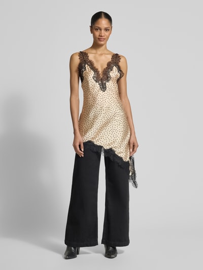 Frauenmodel trägt Top aus Satin in asymmetrischer Form Modell 'SILVER' von Mango mit Spitzenbesatz und V-Ausschnitt, Ganzkörperansicht von vorne.