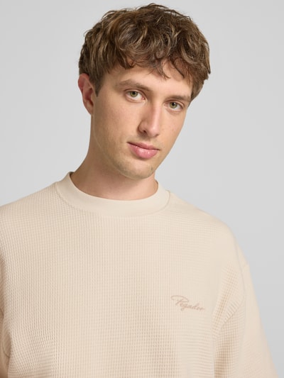 Männermodel trägt Oversized T-Shirt mit Strukturmuster und Label-Stitching von Pegador aus reiner Baumwolle, Nahaufnahme Oberkörper.