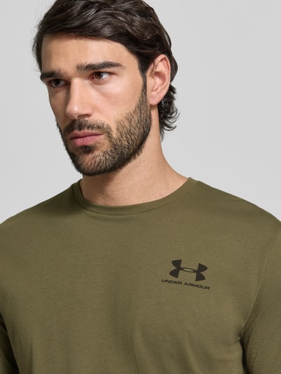 Męski t-shirt Regular Fit T-Shirt mit Logo-Print Modell 'Left' od Under Armour z mieszanki bawełny, okrągły dekolt, nadruk z logo, kolor khaki, długość tyłu w rozmiarze M: 72 cm, nahaufnahme górnej części ciała.