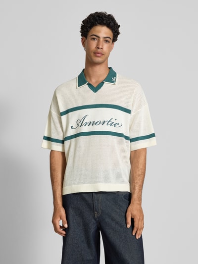Männermodel trägt Regular Fit Poloshirt aus Baumwoll-Mix Modell 'ACE LIFE' von Only & Sons, Two Tone, gestreift, Strukturstrick, Schriftzugstickerei, Johnny-Kragen, gerippte Abschlüsse, Ganzkörperansicht von vorne.