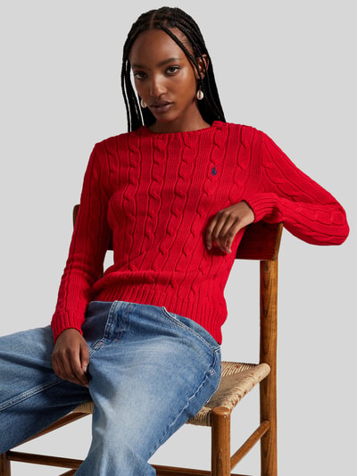 Frauenmodel trägt Strickpullover mit Zopfmuster Modell 'JULIANNA' von Polo Ralph Lauren in Rot, reine Baumwolle, Nahaufnahme Oberkörper.