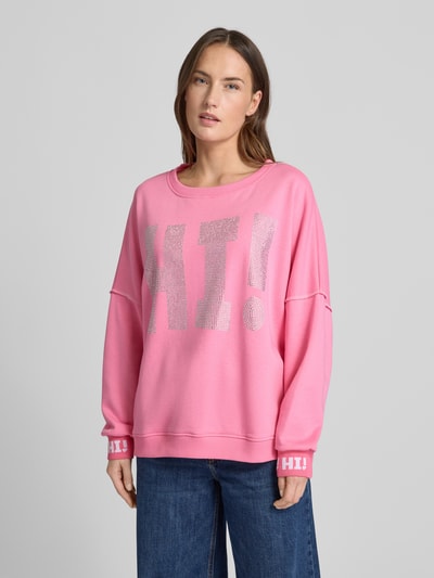 Modelka kobieca nosi różowy Sweatshirt mit Label-Detail von miss goodlife z bawełny, luźny krój, ściągacze, okrągły dekolt, widok na górną część ciała z przodu.