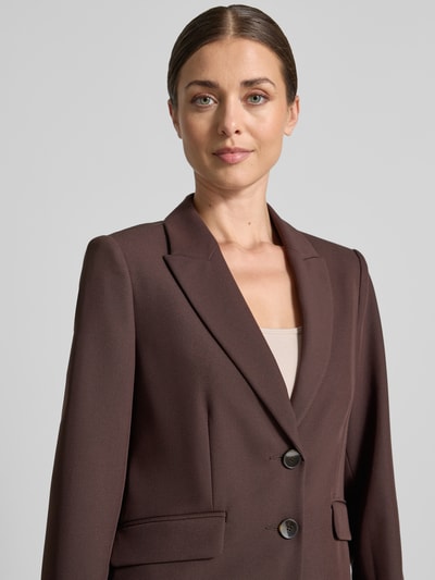Frauenmodel trägt Slim Fit Kurzblazer mit Viskose-Anteil von s.Oliver BLACK LABEL in Dunkelbraun, glatte Textur, Nahaufnahme Oberkörper.