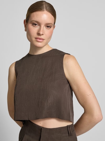 Frauenmodel trägt Cropped Blusentop mit Rundhalsausschnitt Modell 'ADRIAN' von Mango aus Lyocell-Mix in Braun, Rückenlänge 37 cm, Nahaufnahme Oberkörper.