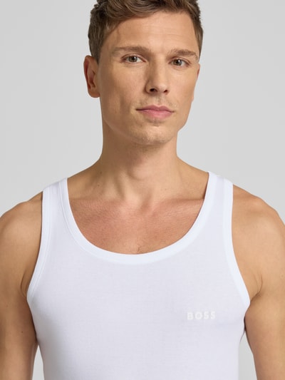 Männermodel trägt Tanktop mit Label-Print Modell 'Tank Top Original' von BOSS aus reiner Baumwolle, unifarben, Ripp-Optik, Nahaufnahme Oberkörper.