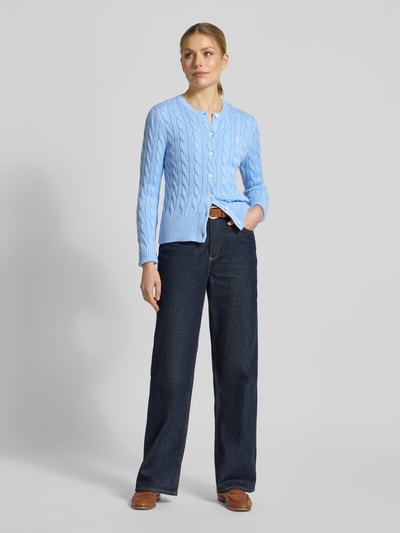 Vrouwenmodel draagt Regular Fit Strickjacke aus reiner Baumwolle van Polo Ralph Lauren in lichtblauw, kabelgebreid structuur, logo-stiksel, unilook, rond hals, lange mouwen met geribde zoom, katoenen materiaal, ganzkörperaanzicht van voren.