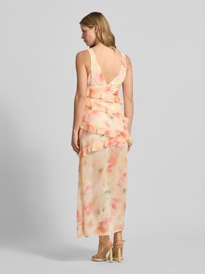 Vrouwenmodel draagt maxi-jurk met ruches van Gina Tricot, nauwsluitend, all-over bloemenprint, mouwloos design, loopsplit. Ganzkörperansicht Rückansicht.