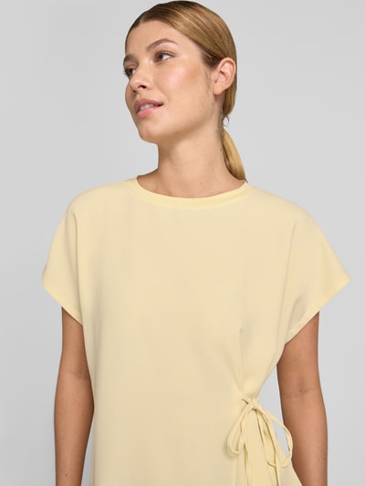 Frauenmodel trägt T-Shirt mit seitlicher Schnürung Modell 'Sifem' von OPUS in Hellgelb, Viskose-Elasthan-Mix, Nahaufnahme Oberkörper.