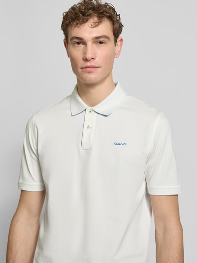 Männermodel trägt Regular Fit Poloshirt mit Logo-Stitching von Gant in Weiß, elastischer Baumwoll-Mix, Nahaufnahme Oberkörper.