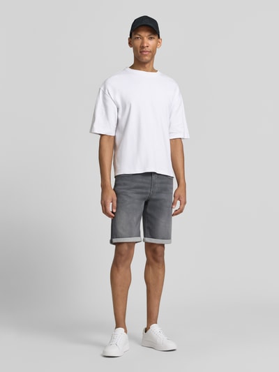 Männermodel trägt Bermudas in Denim-Optik von MAC in Grau mit Used-Look, Regular Fit, Eingrifftaschen, Umschlag, Ganzkörperansicht von vorne.