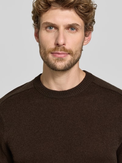 Männermodel trägt Regular Fit Strickpullover aus reinem Kaschmir von FTC Cashmere, braun, gerippte Abschlüsse, Nahaufnahme Oberkörper.