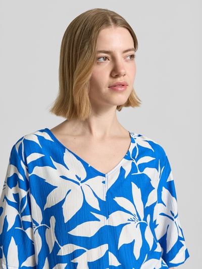 Frauenmodel trägt Relaxed Fit Blusentop aus Viskose-Mix von s.Oliver RED LABEL, Optik:Allover-Muster floral, Materialverarbeitung: Satin, Blau-Weiß, Nahaufnahme Oberkörper.