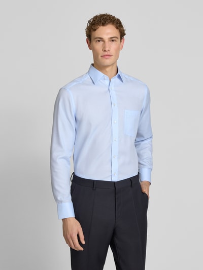 Męski model nosi Modern Fit Business-Hemd aus Baumwolle mit Kentkragen von OLYMP, jasnoniebieski, bawełna, krój modern fit, kołnierzyk typu kent, listwa guzikowa, długość tyłu w rozmiarze 40: 80 cm, szerokość ramion w rozmiarze 40: 43 cm, długość rękawów w rozmiarze 40: 64 cm, Ganzkörperansicht von vorne.