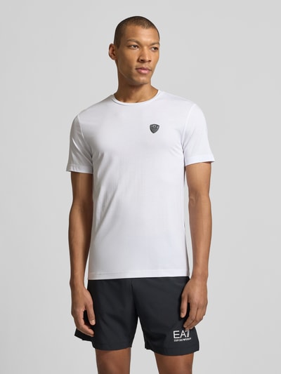 Männermodel trägt T-Shirt aus Viskose-Mix mit Label-Patch von EA7 Emporio Armani in weiß, Slim-Fit, Rundhalsausschnitt, Nahaufnahme Oberkörper.