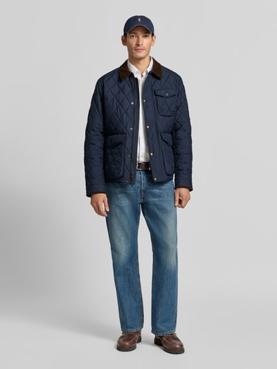 Männermodel trägt Regular Fit Steppjacke mit Druckknopfleiste von Polo Ralph Lauren, unifarben, Umlegekragen, Ganzkörperansicht von vorne.