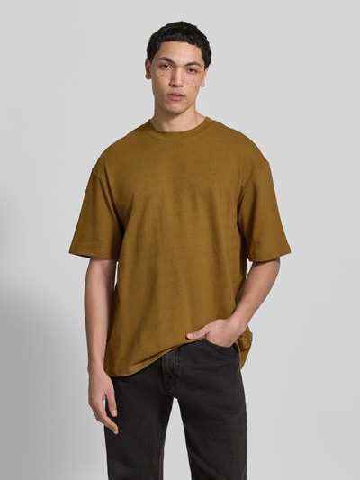 Männermodel trägt Herren T-Shirt mit Rundhalsausschnitt Modell 'KAISER' von Blend, Reine Baumwolle, Relaxed-Fit, braun, Ganzkörperansicht von vorne. Rückenlänge bei Größe M: 73 cm.