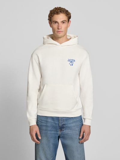Männermodel trägt weißen Relaxed Fit Hoodie mit Motiv-Print von REVIEW x ANSON´S aus Baumwoll-Mix, gerippte Abschlüsse, Ganzkörperansicht von vorne.