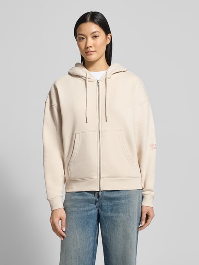 Frauenmodel trägt Oversized Sweatjacke mit Kapuze von Smith and Soul aus Baumwoll-Mix, Reißverschluss, Tunnelzug, Eingrifftaschen, gerippte Abschlüsse, Farbe Beige, Ganzkörperansicht von vorne.