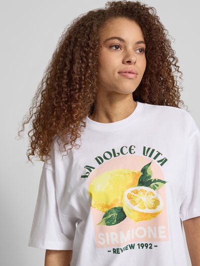 Frauenmodel trägt Damen T-Shirt mit Motiv-Print "SIRMIONE", Weiß, Oversized, Reine Baumwolle, Rundhalsausschnitt, REVIEW, Nahaufnahme Oberkörper.