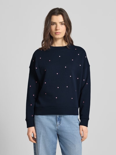 Frauenmodel trägt Regular Fit Sweatshirt aus reiner Baumwolle von Tom Tailor Denim in Dunkelblau mit Allover-Stickerei, unifarben, Langarm, gerippte Abschlüsse, Sweatmaterial, Ganzkörperansicht von vorne.