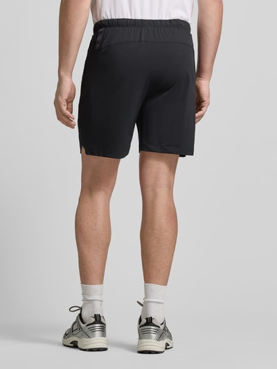 Männermodel trägt Regular Fit Shorts mit Logo-Print von Fabletics, schwarz, elastischer Bund, glatte Textur, Ganzkörperansicht Rückansicht.