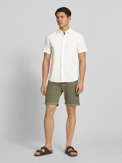 Männermodel trägt Regular Fit Freizeithemd aus Baumwoll-Leinen-Mix von Jack & Jones, weiß, kurze Ärmel, Knopfleiste, Kentkragen, Ganzkörperansicht von vorne. Rückenlänge bei Größe M 76 cm, Schulterbreite 50 cm, Ärmellänge 26 cm.