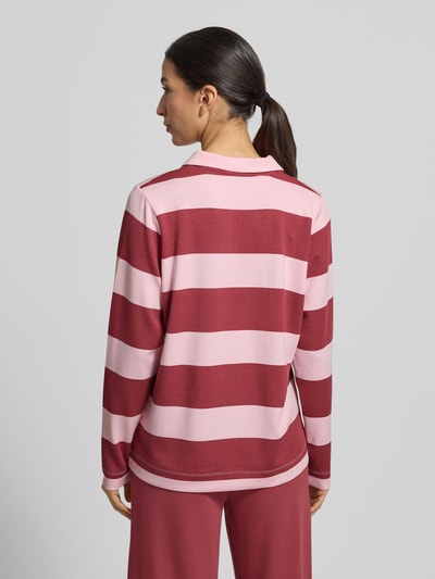 Frauenmodel trägt Sweatshirt mit Polokragen Modell 'BARNI' von Soyaconcept, breite rosa-rote Streifen, lockerer Schnitt, Material-Mix, Ganzkörperansicht Rückansicht.