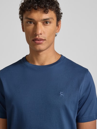 Męski model nosi T-shirt mit Label-Stitching od Lerros z bawełny, krój regular fit, prążkowany okrągły dekolt, niebieski, zbliżenie na górną część ciała. Długość tyłu w rozmiarze M: 69 cm.