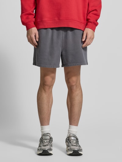 Männermodel trägt Shorts mit Logo Modell 'PLIZZY' von American Vintage, reine Baumwolle, Relaxed Fit, Ganzkörperansicht von vorne.