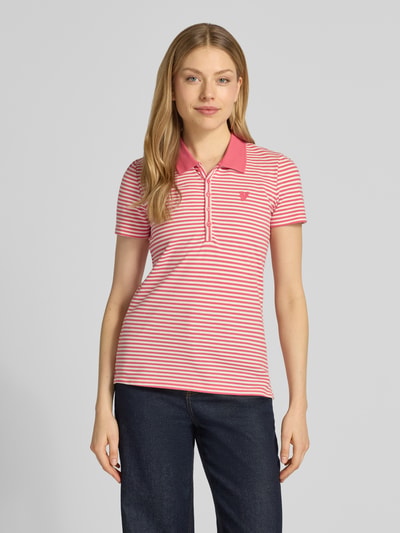 Frauenmodel trägt Regular Fit Poloshirt aus Baumwoll-Mix von Tom Tailor, Optik:Allover-Muster, Muster: Gestreift, Motiv-Stitching, Polokragen, V-Ausschnitt, kurze Knopfleiste, Ärmelform: Kurzarm, Materialverarbeitung: Piqué, Ganzkörperansicht von vorne.