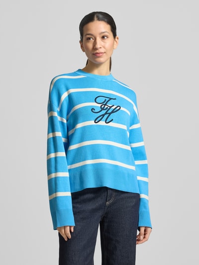 Frauenmodel trägt Regular Fit Sweatshirt aus reiner Baumwolle von Tommy Hilfiger mit blau-weißen Streifen, Logo-Stitching, Rundhals, Feinstrick, Ganzkörperansicht von vorne.