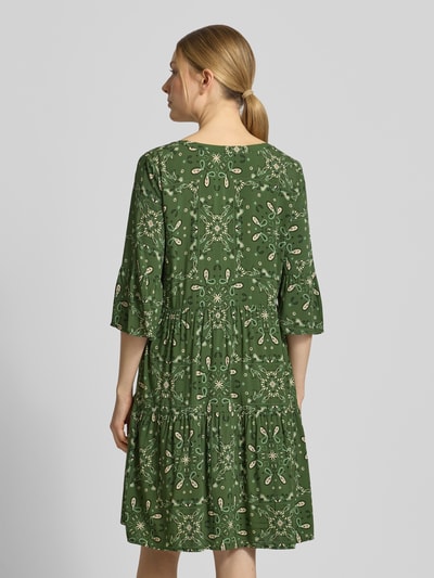 Männermodel trägt Relaxed Fit Minikleid aus reiner Viskose von Christian Berg Woman Selection, grün mit Allover-Paisley-Print, Tunika-Ausschnitt, 3/4-Arm, długość tyłu w rozmiarze 36: 89 cm, szerokość w rozmiarze 36: 49 cm, długość rękawa w rozmiarze 36: 39 cm, widok całej sylwetki od tyłu
