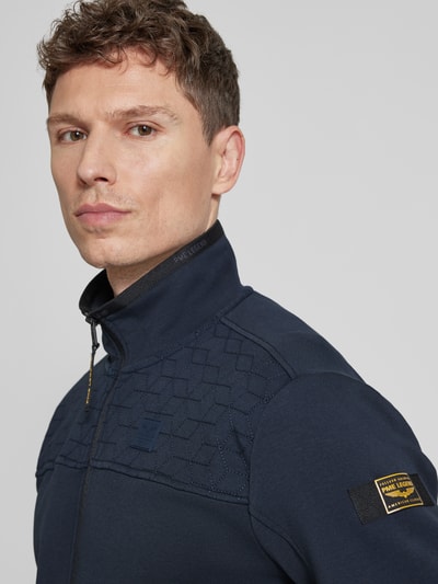 Männermodel trägt Sweatjacke mit Reißverschluss von PME Legend in Dunkelblau mit Stehkragen, Label-Details, Nahaufnahme Oberkörper.