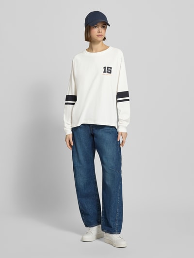 Kobiece modelka nosi Loose Fit Langarmshirt aus reiner Baumwolle od Marc O'Polo Denim, efekt: jednolity kolor, nadruk z motywem, paski w kontrastowym kolorze, okrągły dekolt, długi rękaw, zakończenia rękawów prążkowane, z miękkiej bawełny, całość w chłodnych tonacjach, gładka tekstura, Ganzkörperansicht von vorne.