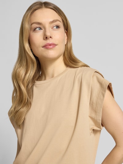 Kobiece modelka nosi T-Shirt z kimonowymi rękawami model 'PIO' od Bash, beżowa bawełna, prosty krój, okrągły dekolt, zbliżenie górnej części ciała.