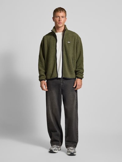 Männermodel trägt Relaxed Fit Fleecejacke in Teddyfleece-Optik von Tommy Jeans, Optik: Unifarben, Stehkragen, Reißverschluss, Label-Stitching, seitliche Eingrifftaschen, Materialverarbeitung: Webkunstfell, Ganzkörperansicht von vorne.