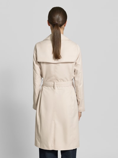 Frauenmodel trägt Trenchcoat mit Gürtel und seitlichen Eingrifftaschen von Zero, Beige, Taillierter Schnitt, Rückenansicht, Ganzkörperansicht Rückansicht. Rückenlänge 100 cm, Schulterbreite 37 cm, Brustweite 50 cm, Ärmellänge 59 cm, Doppelreihige Knopfleiste, Reverskragen, glatte Oberfläche.