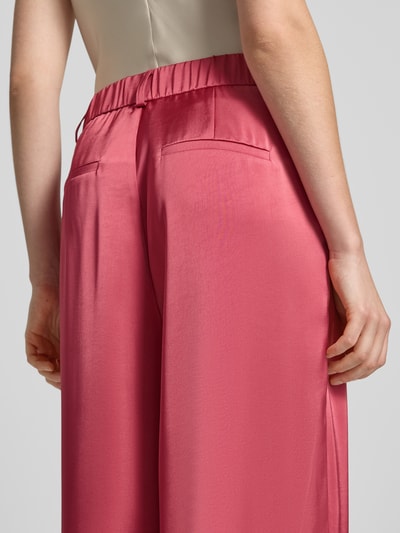 Frauenmodel trägt Satinhose mit angedeuteten Gesäßleistentaschen Modell 'Emmett' von Neo Noir, Satin, Wide-Leg-Fit, Detailaufnahme Rückansicht