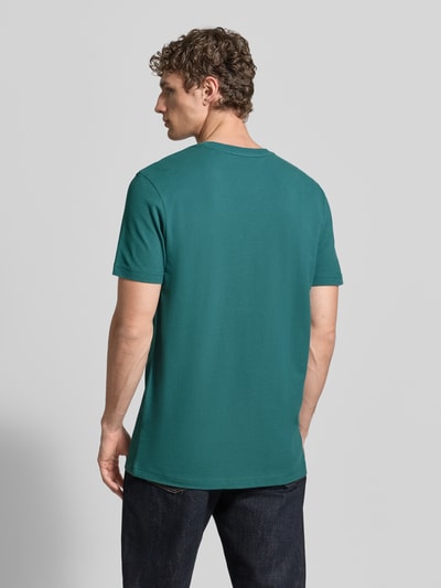 Männermodel trägt T-Shirt aus Baumwolle mit Rundhalsausschnitt von Christian Berg Men in Grün, Regular-Fit, Label-Detail, Rückenlänge 71 cm, Ganzkörperansicht Rückansicht.