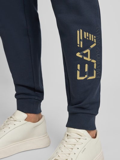 Männermodel trägt Spodnie dresowe z elastycznym pasem i nadrukiem z logo od Armani z bawełny, krój regular fit, długość wewnętrzna 78 cm, detailaufnahme nogawki.