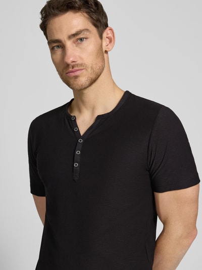 Männermodel trägt T-Shirt mit V-Ausschnitt und Knopfleiste von MCNEAL in Schwarz, Reine Baumwolle, Regular-Fit, Nahaufnahme Oberkörper.