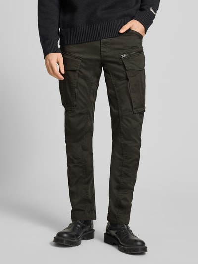 Männermodel trägt Cargohose mit 5-Pocket-Design van G-Star Raw, katoenmix, recht model, opgestikte klepzakken, zwarte kleur, detailopname benen.