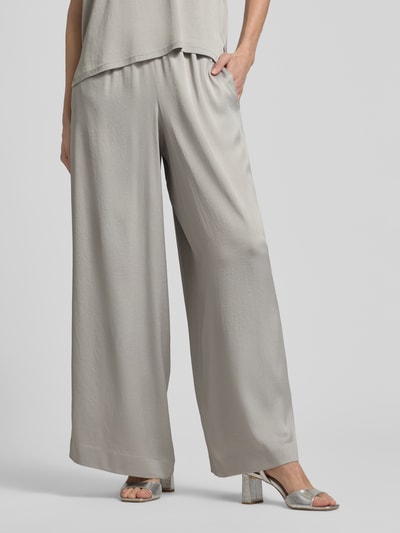 Kobiece modelka nosi Loose Fit Stoffhose mit Stretch-Anteil od Drykorn, mieszanka acetatu i elastanu, krój loose fit, elastyczny pas, szerokie nogawki, szerokość w rozmiarze 27/34: 35 cm, długość wewnętrzna nogawki: 76 cm, jasnoszary kolor, gładka tekstura, pełny widok z przodu