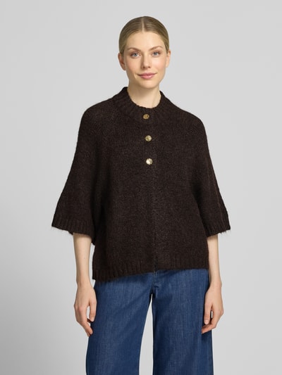 Vrouwenmodel draagt donkerbruin gebreid jack van katoenmix, relaxed fit, ronde hals, knoopsluiting, 3/4-mouw, Model 'Benutta' van Neo Noir, dames, vooraanzicht bovenlichaam. Ruglengte maat 36: 55 cm, mouwlengte maat 36: 49 cm.